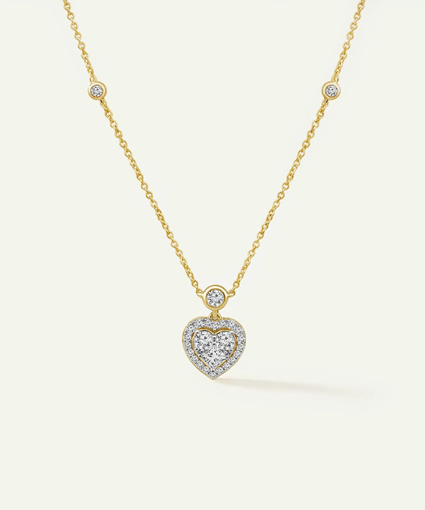 Gold necklace with a heart-shaped diamond pendant on a white background