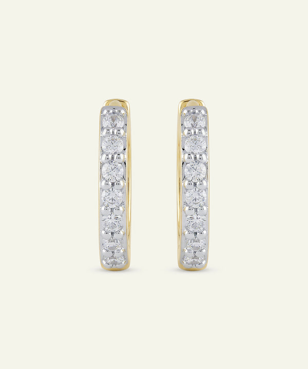 Pair of diamond hoop earrings on a light beige background
