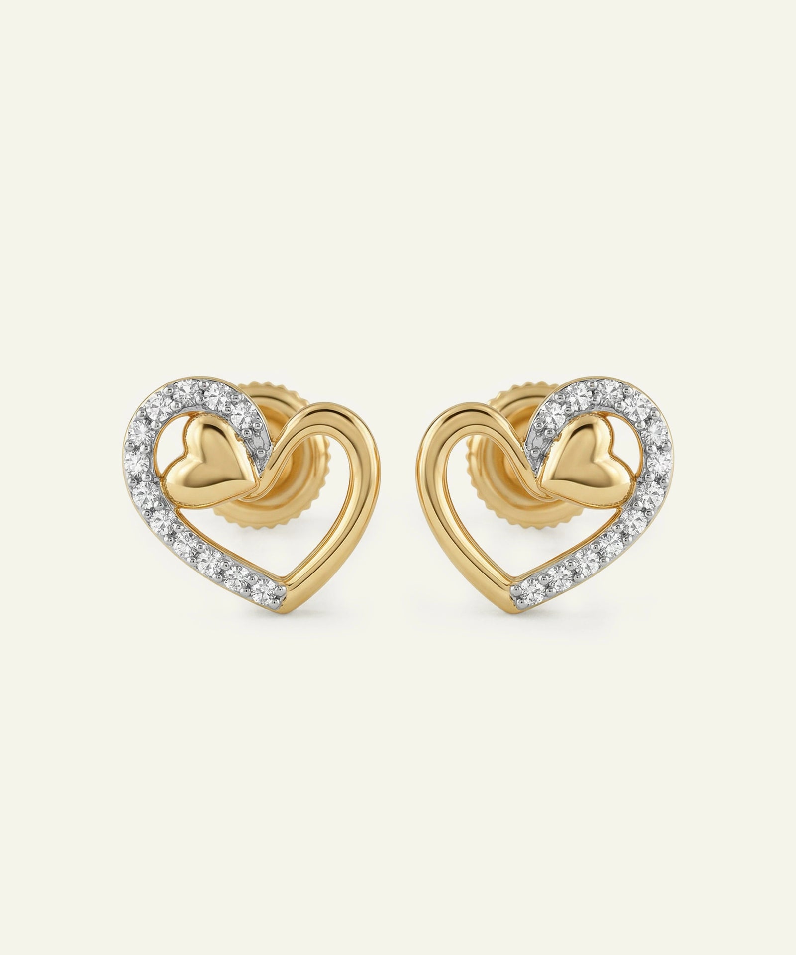 Gold heart-shaped earrings with diamond accents on a white background