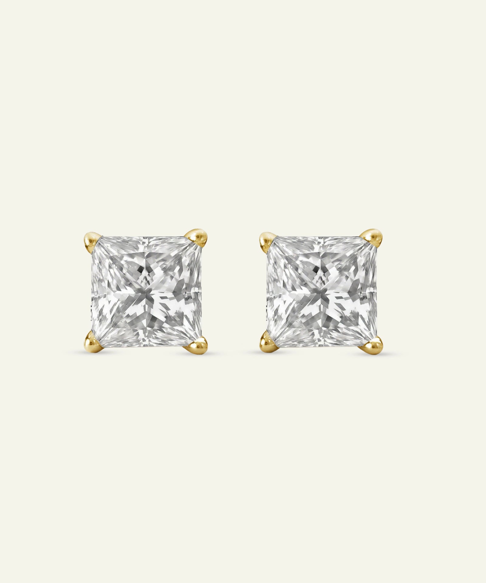 Pair of gold square-cut stud earrings on a white background