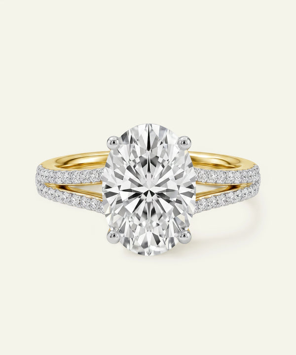 Oval-cut diamond ring with a yellow gold and pavé diamond split band.