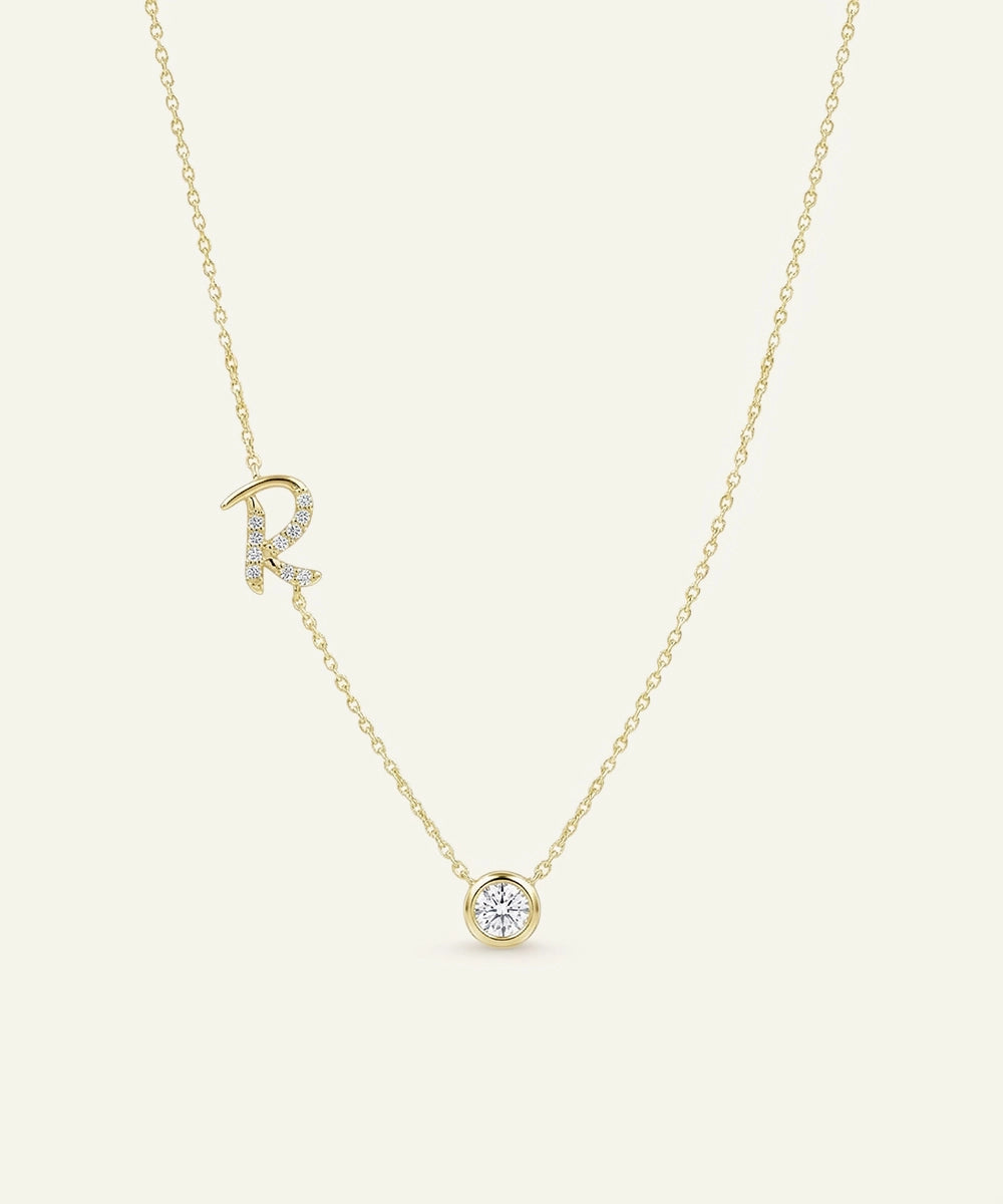 Gold necklace with a diamond pendant on a light beige background