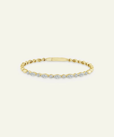 Gold bracelet with diamonds on a light beige background