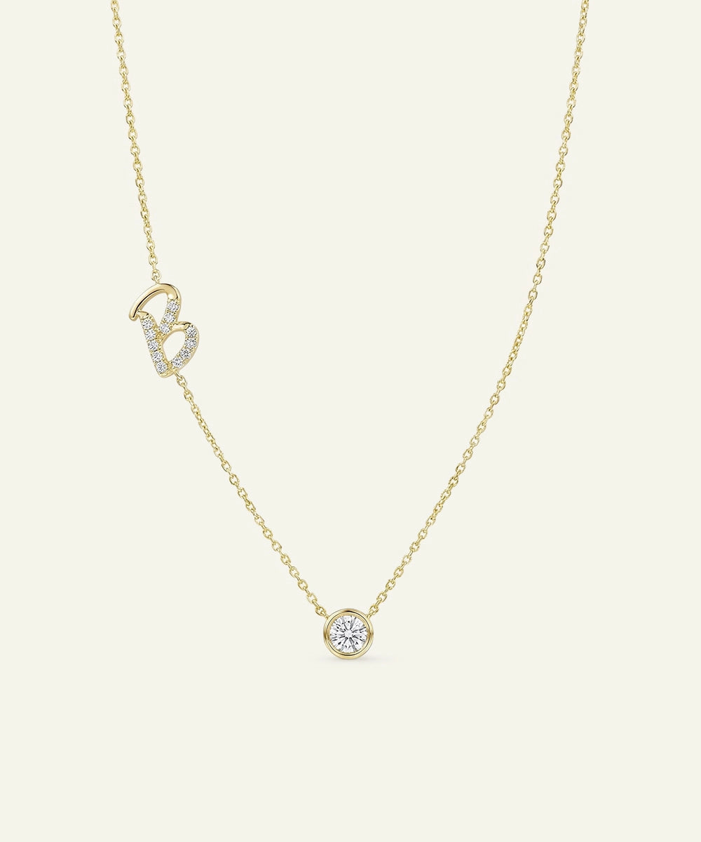 Gold necklace with a small round pendant on a light beige background