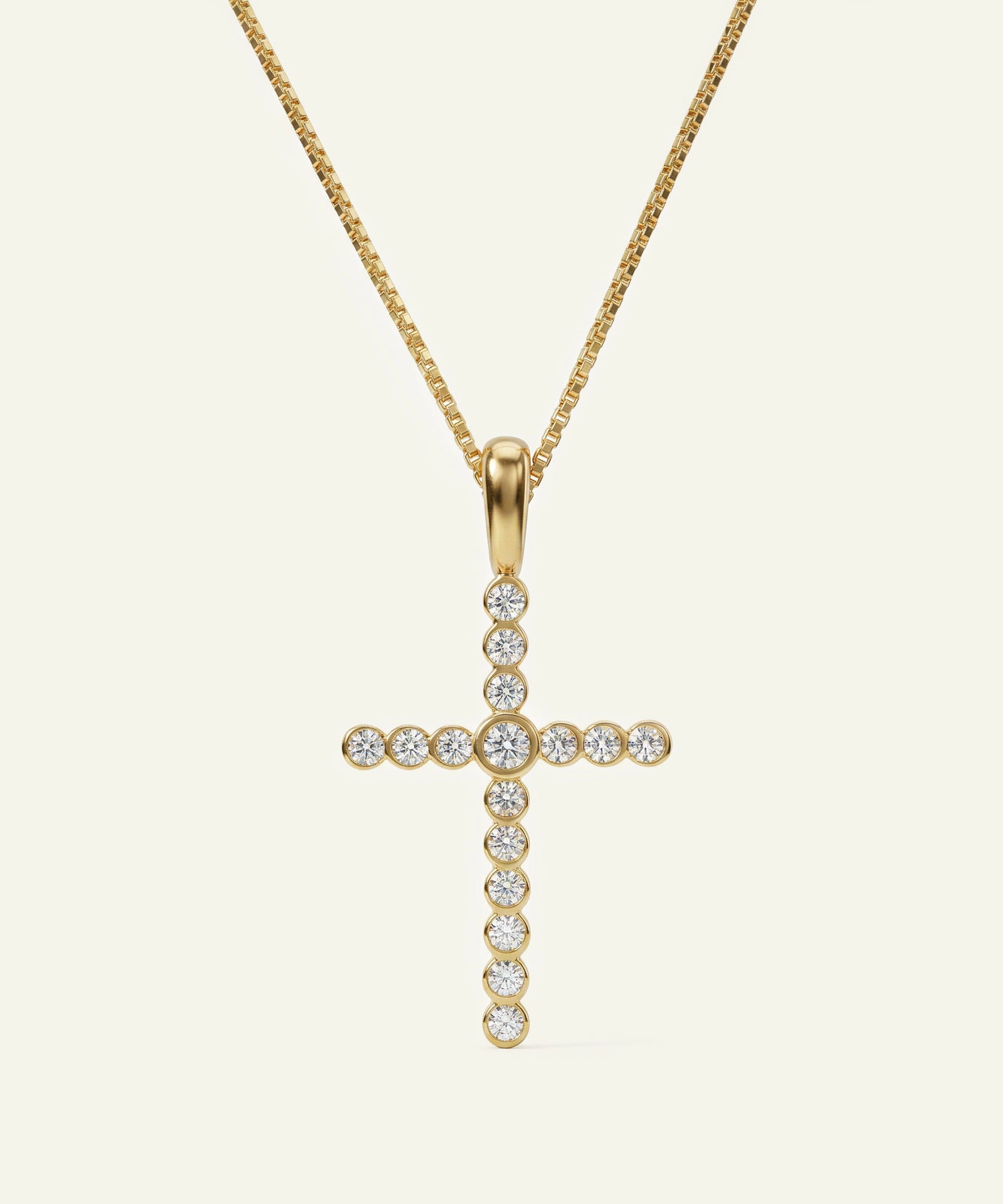 Gold cross pendant necklace with clear stones on a white background
