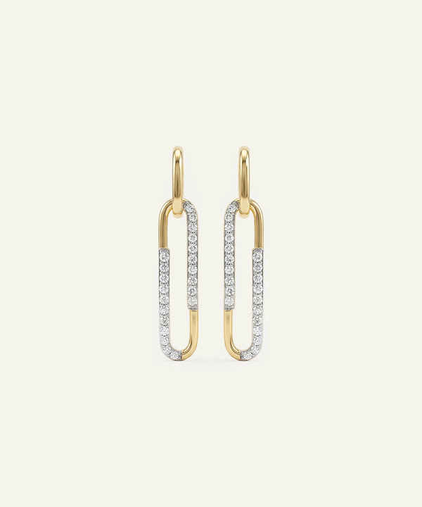 Gold and silver earrings on a light beige background