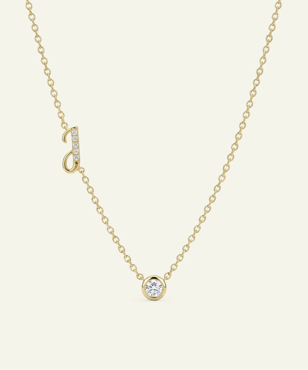Gold necklace with a small round pendant on a light beige background
