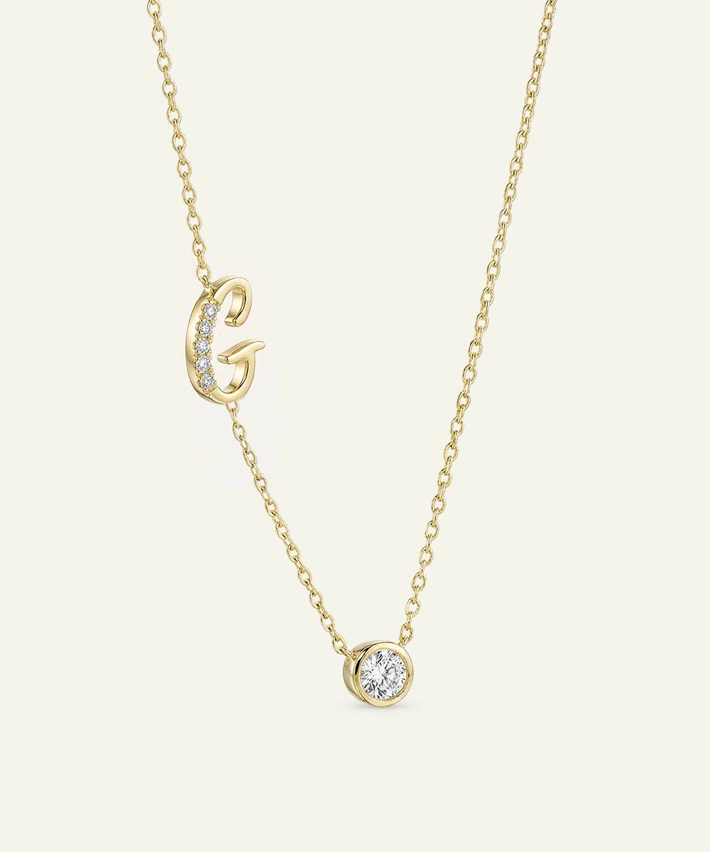 Gold necklace with a small round pendant on a light beige background