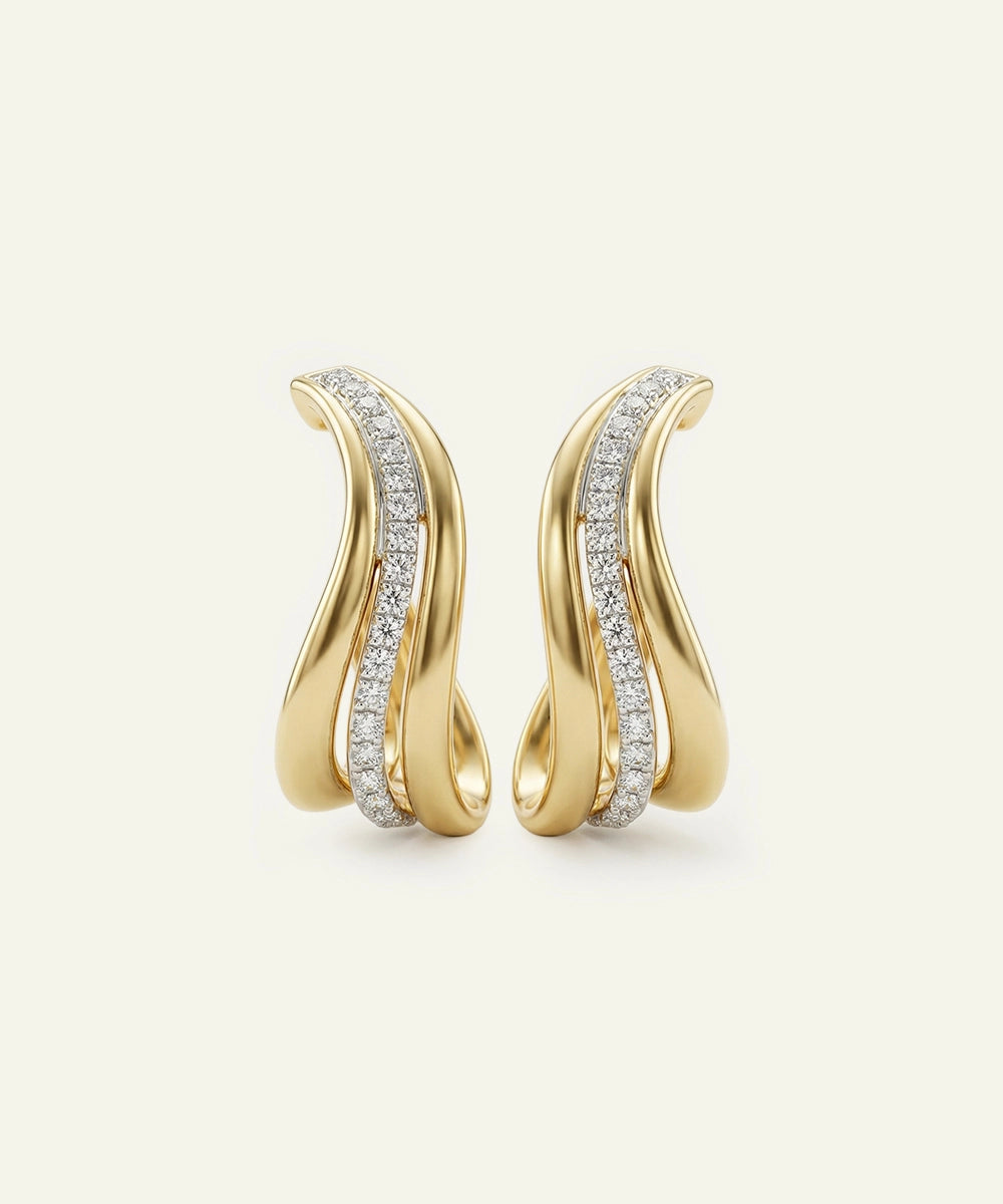 Gold earrings with diamond accents on a light beige background