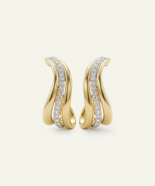 Gold earrings with diamond accents on a light beige background