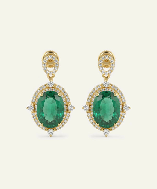 Gold earrings with green gemstones on a white background