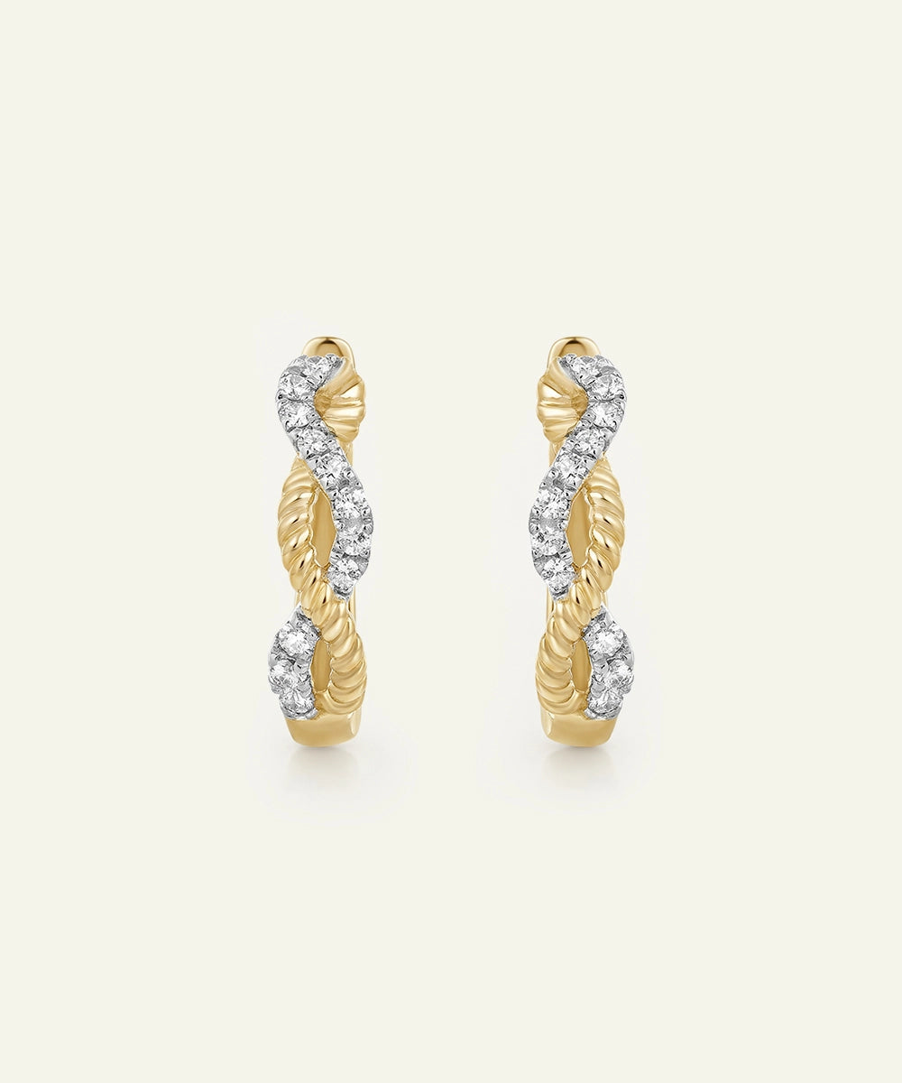 Pair of gold hoop earrings with diamond accents on a light beige background