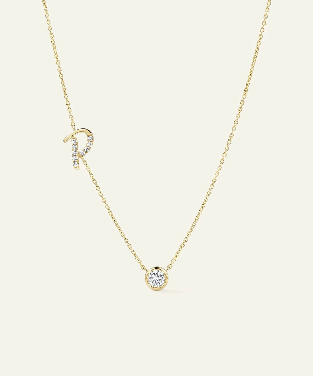 Gold necklace with a diamond pendant on a light beige background