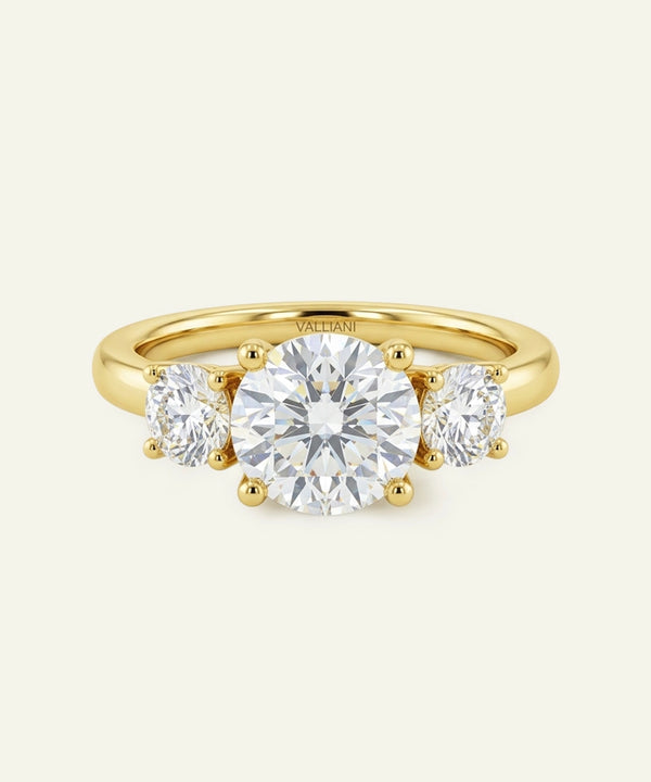 Gold ring with three diamonds on a white background