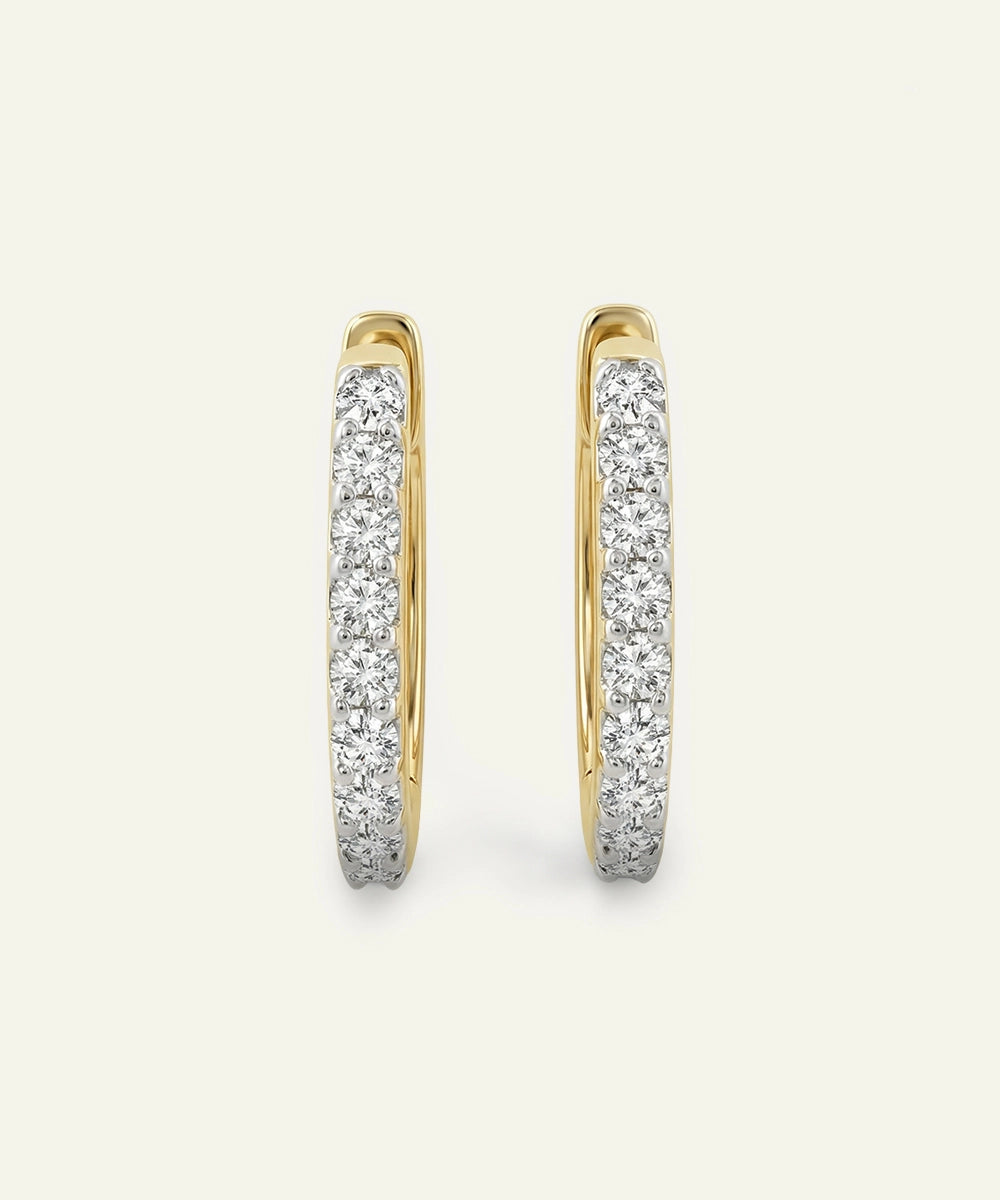 Gold hoop earrings with diamond accents on a light gray background