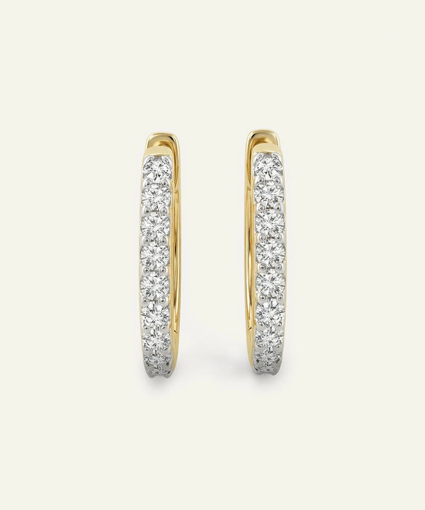 Gold hoop earrings with diamond accents on a light gray background