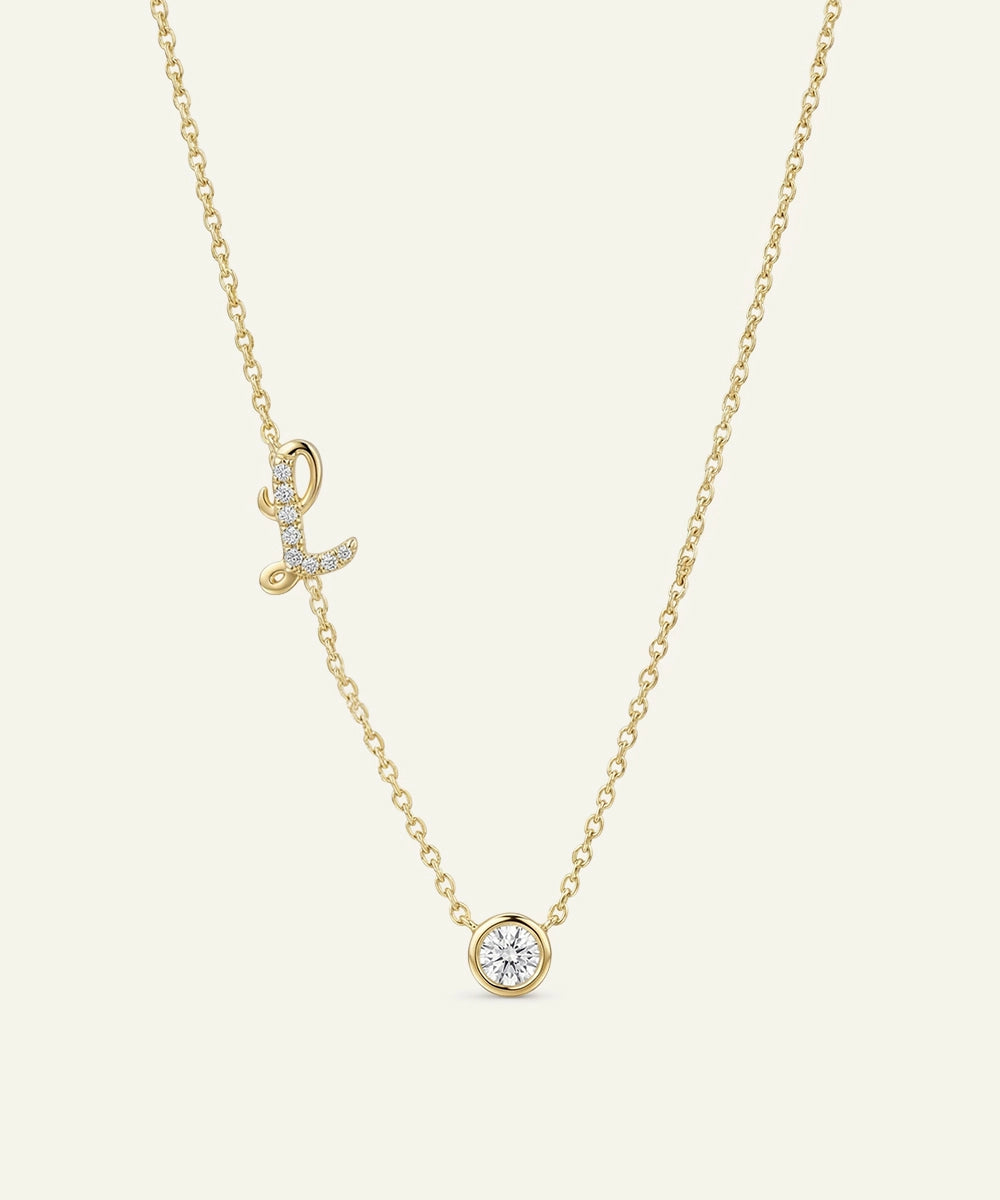 Gold necklace with diamond pendants on a light beige background
