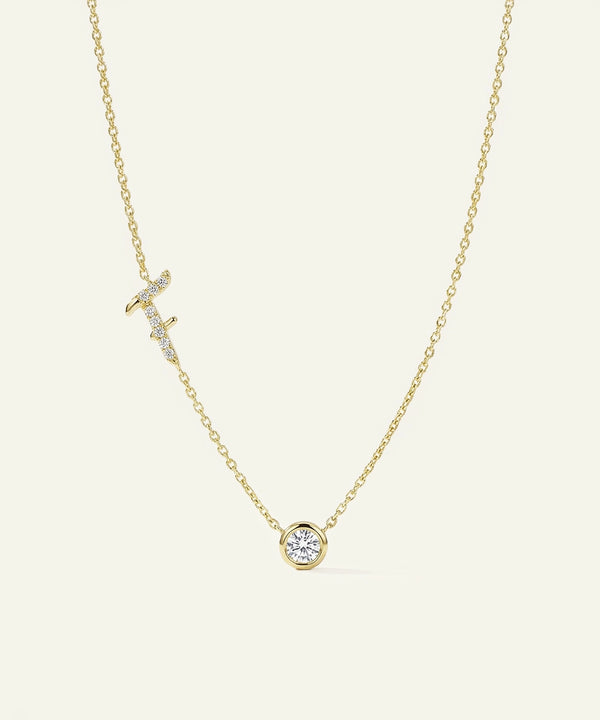 Gold necklace with diamond pendants on a light beige background