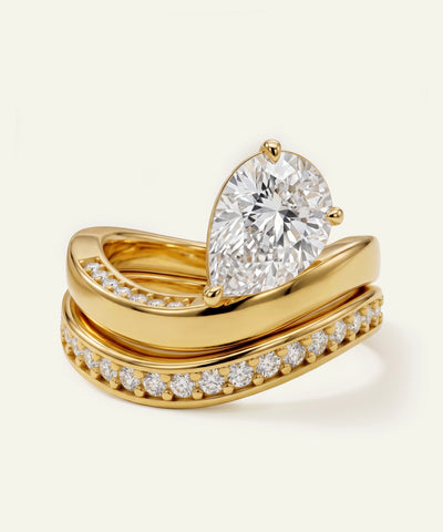 Gold ring with a large diamond and smaller diamonds on a beige background