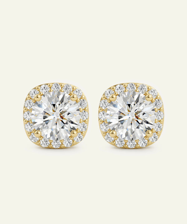 Gold and diamond earrings on a beige background