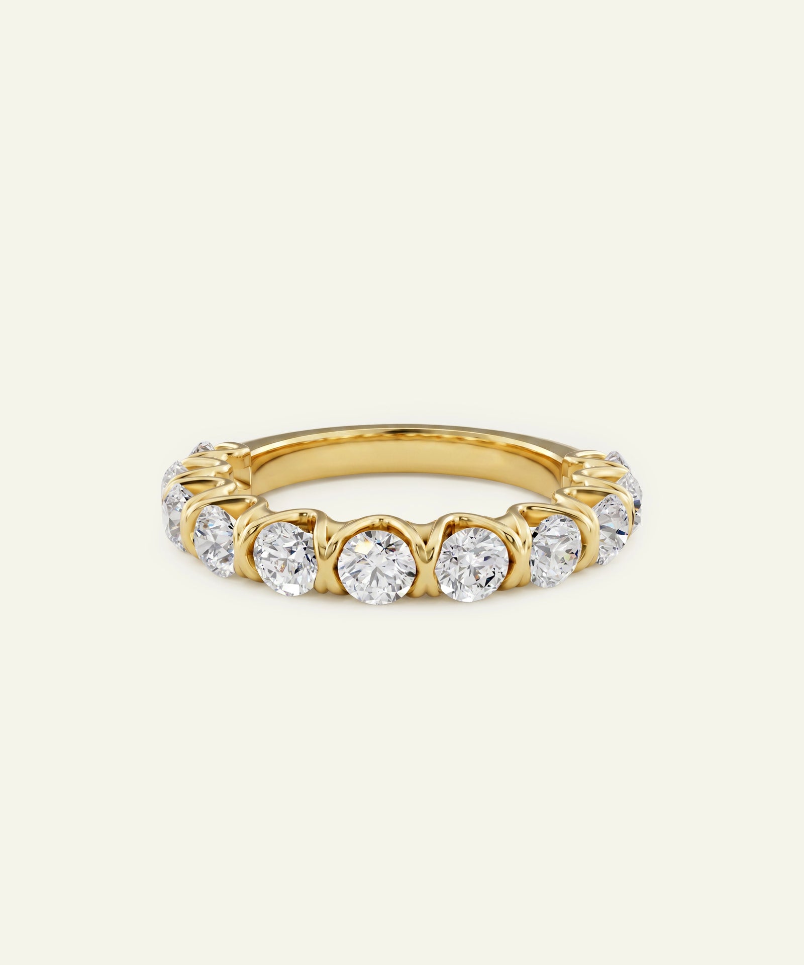 A yellow gold eternity ring featuring a row of round-cut clear gemstones in a prong setting, shown against a plain off-white background.
