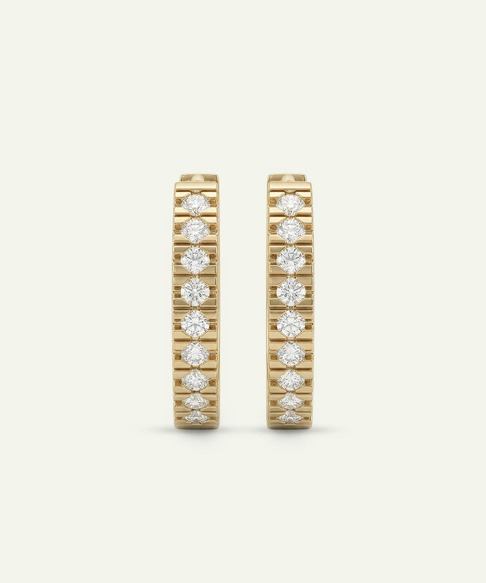 Two gold rings with diamond accents on a beige background