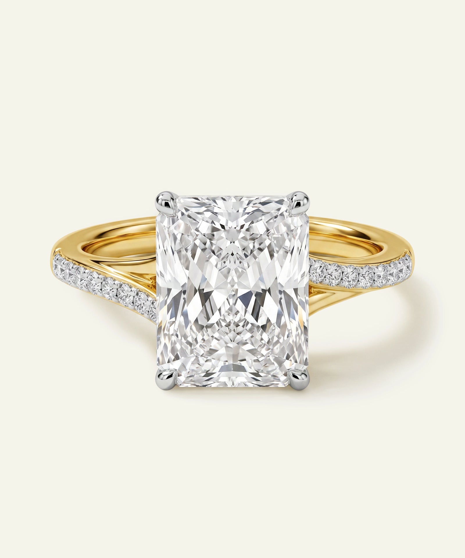 Radiant-cut diamond ring with a yellow gold and crossover pavé diamond band.