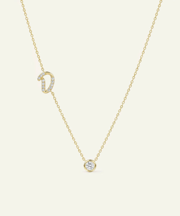 Gold necklace with diamond pendant on a light beige background
