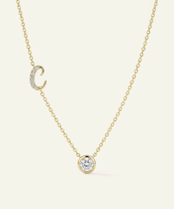 Gold necklace with a diamond pendant on a light beige background