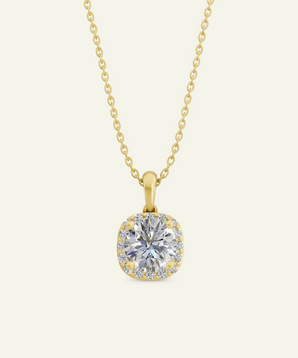 Gold necklace with a diamond pendant on a light beige background