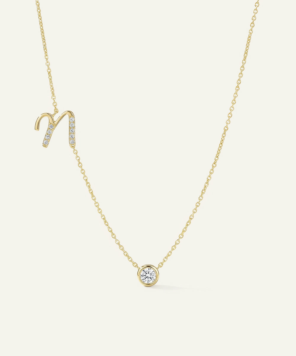 Gold necklace with a zodiac sign pendant on a light beige background