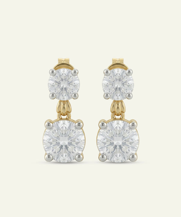Gold earrings with clear gemstones on a white background