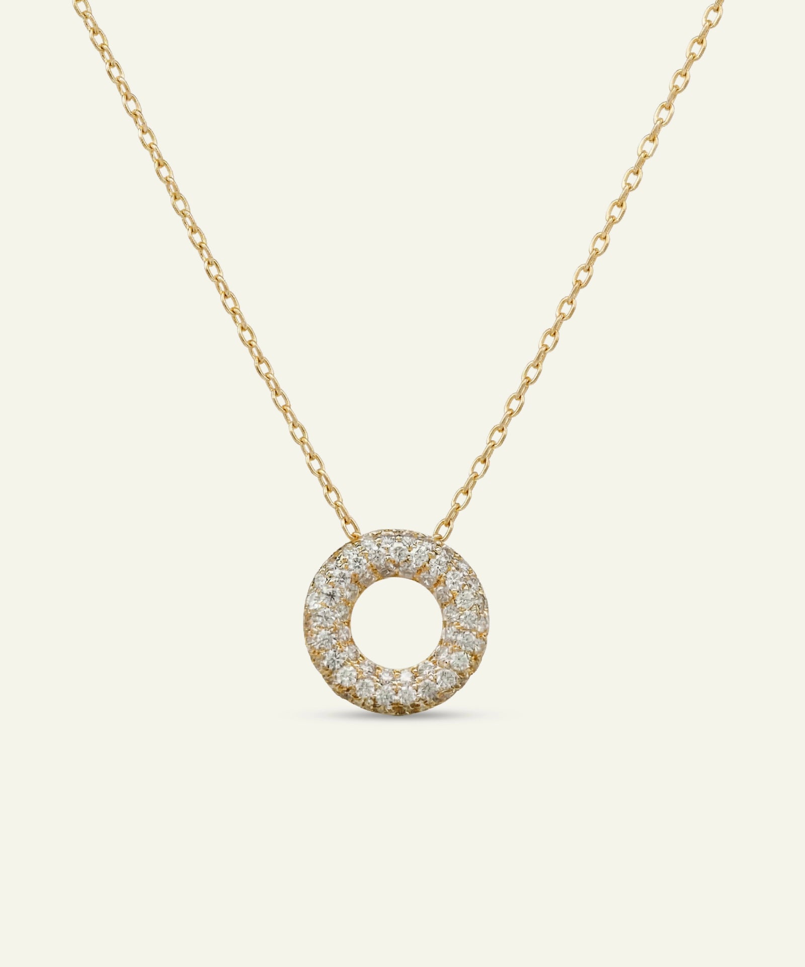 Gold necklace with a round diamond pendant on a white background