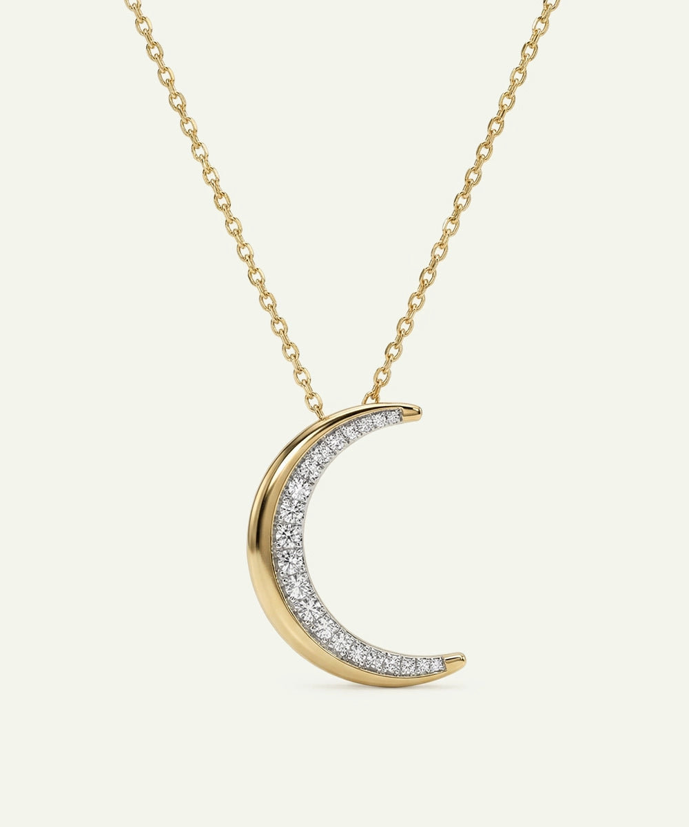 Gold and diamond crescent moon necklace on a white background