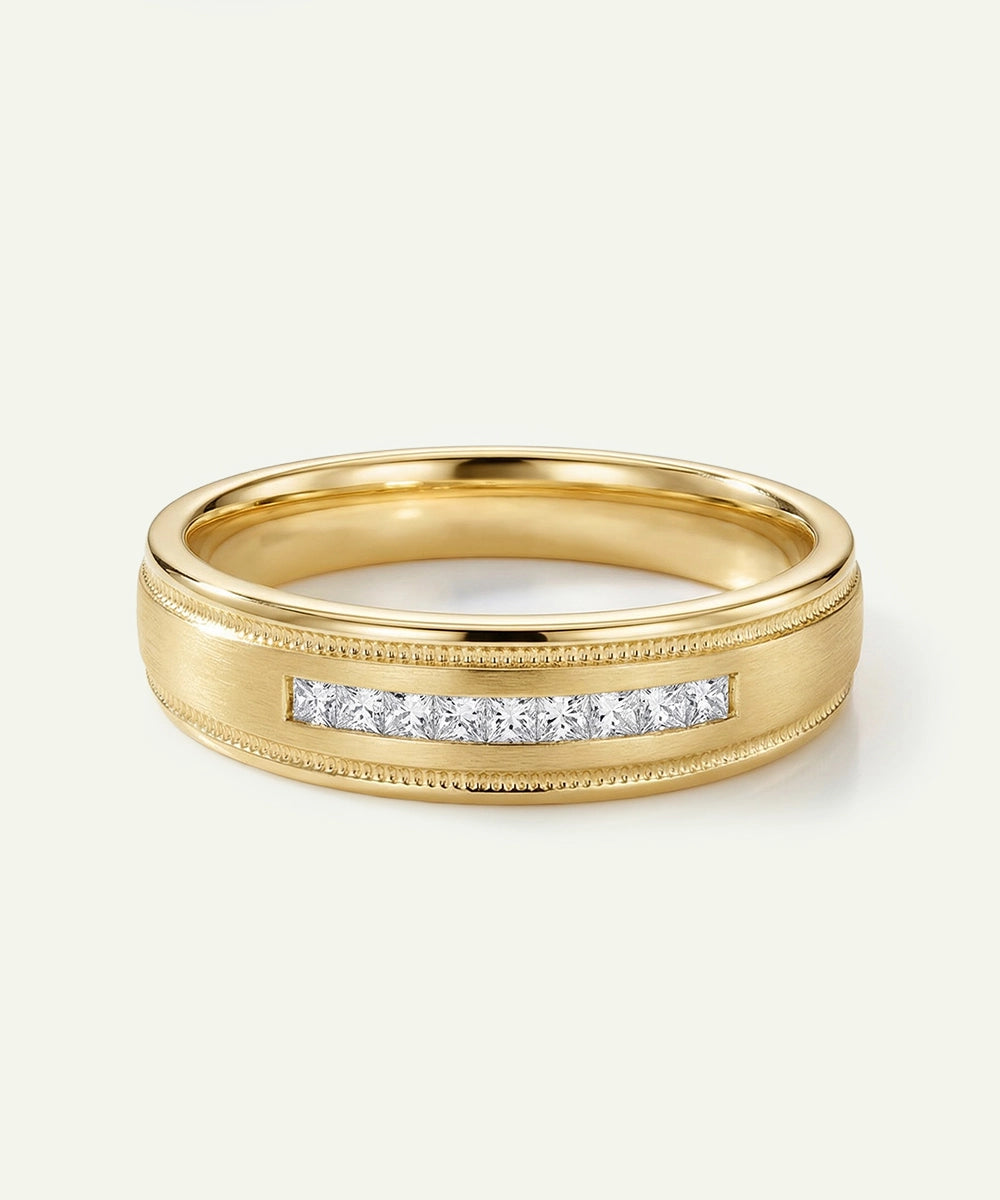 A men's yellow gold wedding band featuring a central row of channel-set princess-cut diamonds, accented by a brushed matte finish and fine milgrain beaded edges.