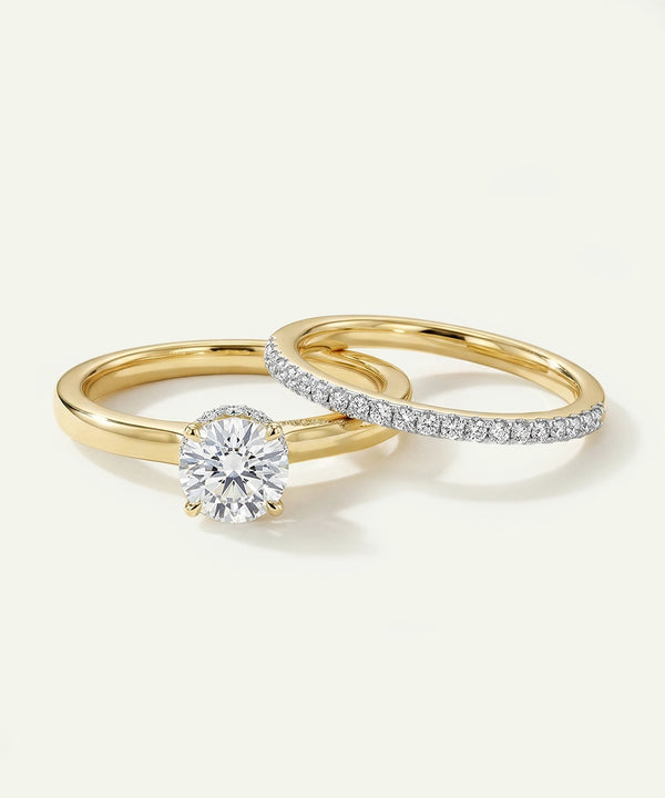 Two gold rings with diamond accents on a light background
