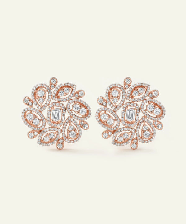 Rose gold earrings with diamond accents on a light beige background