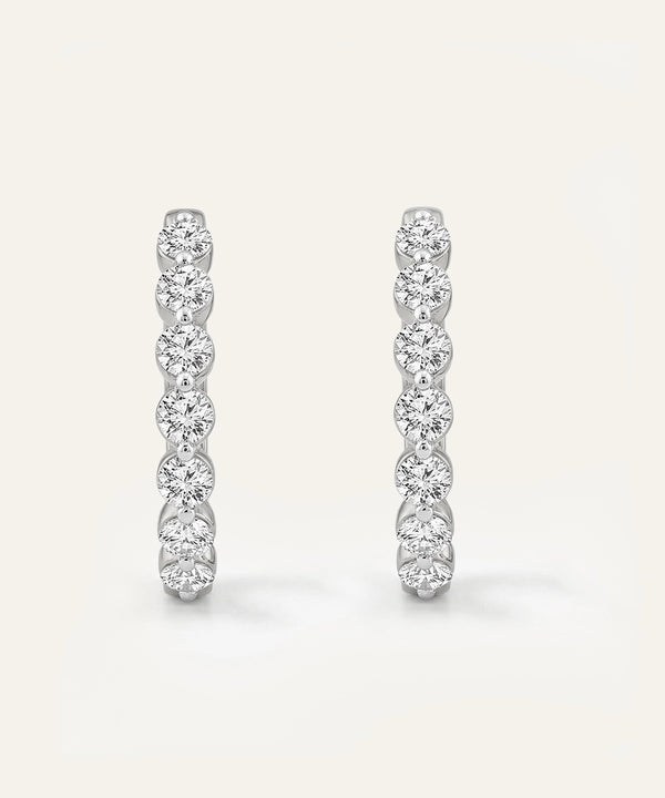 Pair of diamond earrings on a light gray background