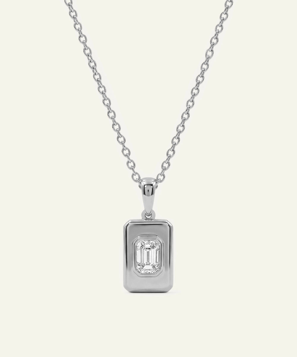Silver necklace with a rectangular diamond pendant on a light gray background