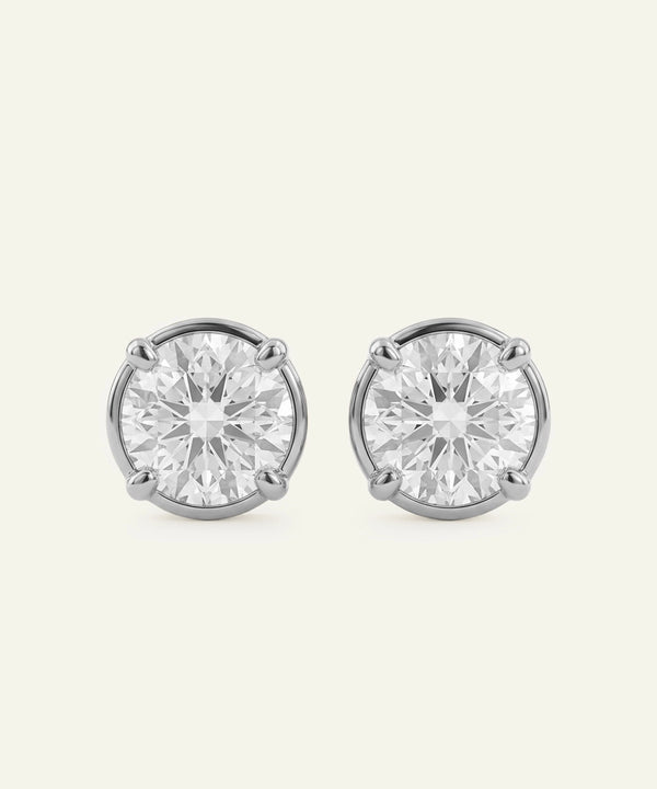 Pair of diamond stud earrings on a light gray background