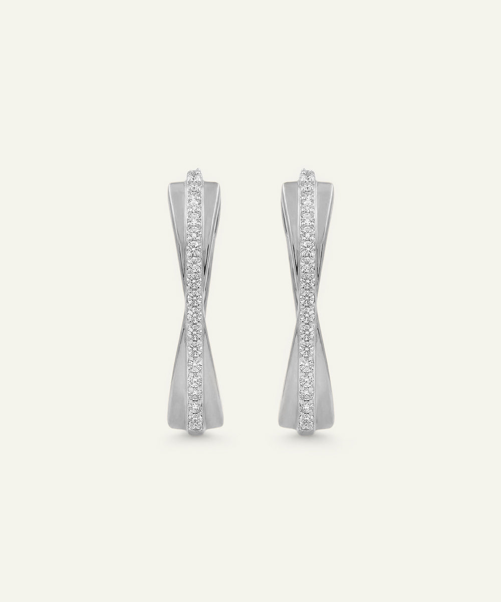 Pair of silver earrings with gemstones on a light gray background