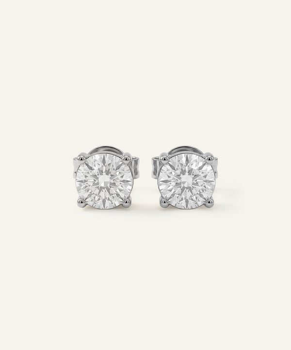 Pair of diamond stud earrings on a light gray background