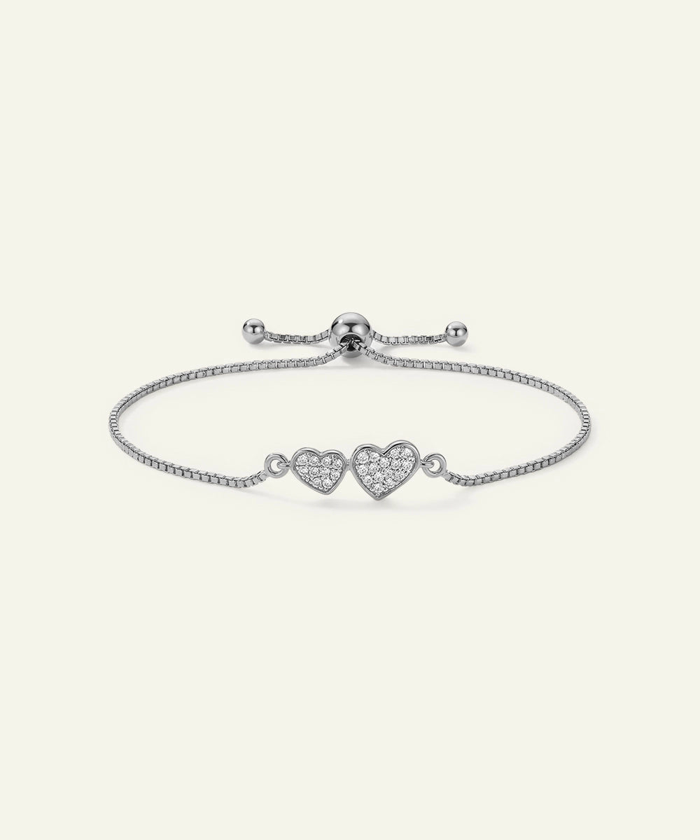 Silver bracelet with heart-shaped charms on a white background