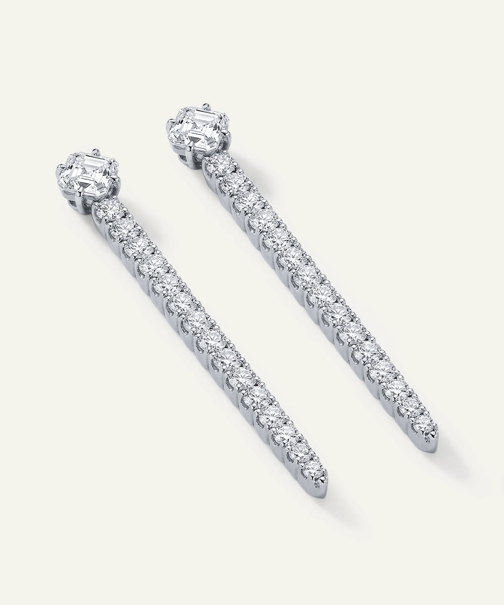 Pair of diamond earrings on a light gray background