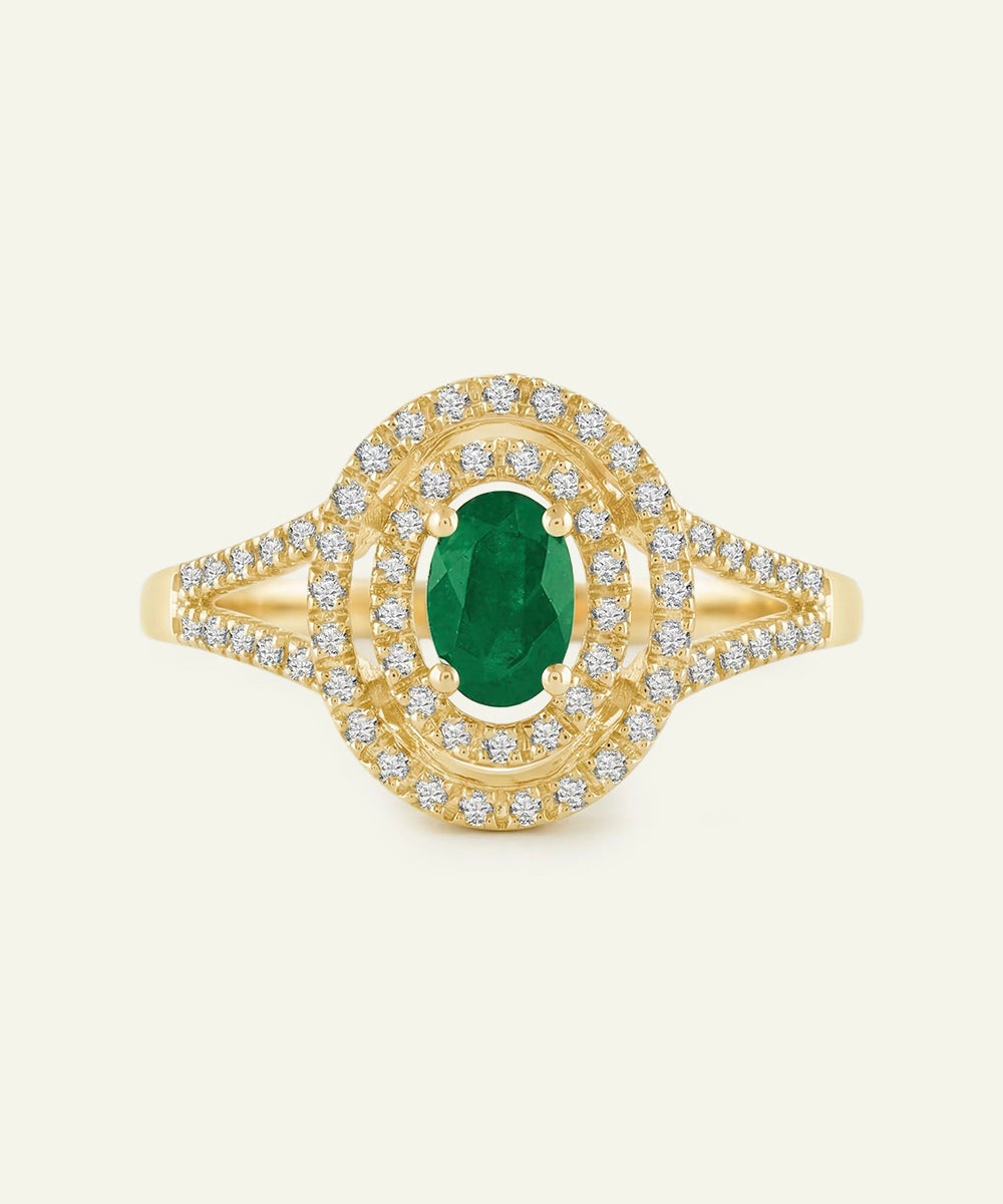 Gold ring with a green gemstone and diamond accents on a white background