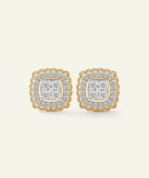 Pair of gold and diamond earrings on a light beige background