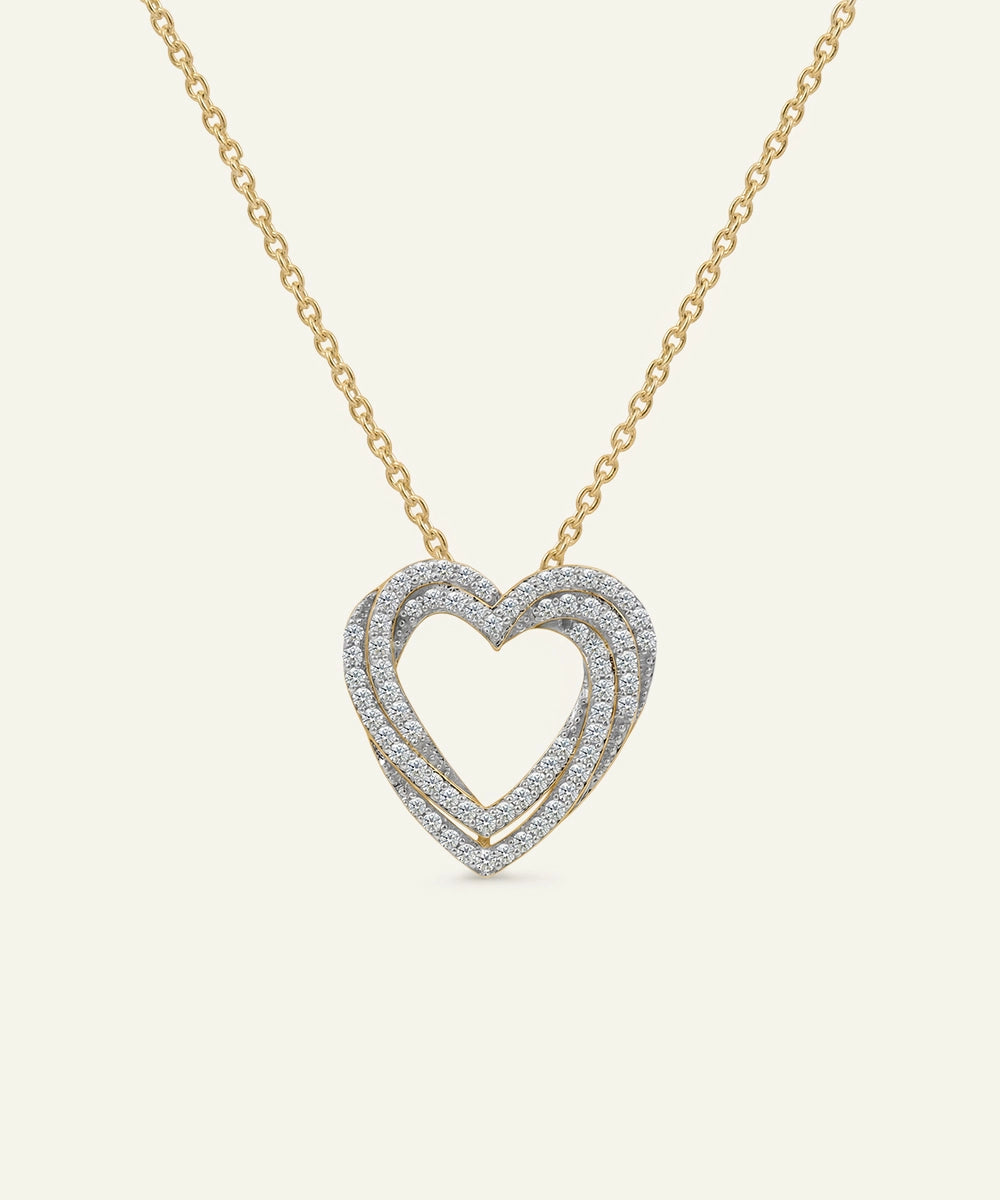 Heart-shaped diamond necklace on a gold chain against a white background