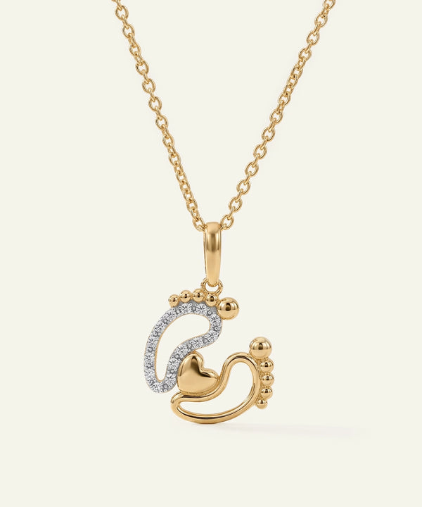 Gold necklace with a heart and footprints pendant on a white background
