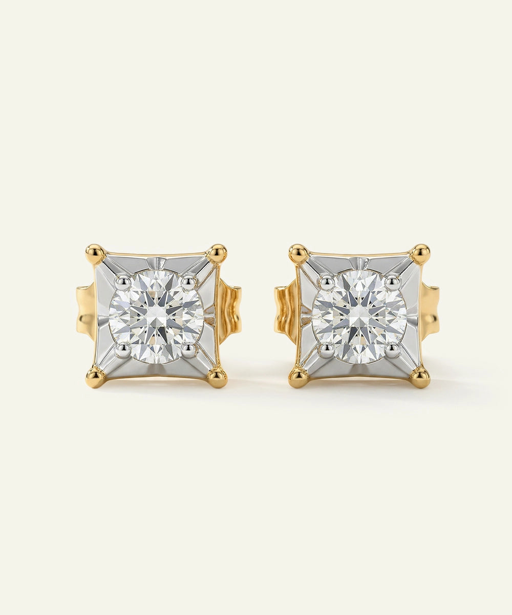 Pair of gold and diamond stud earrings on a light beige background