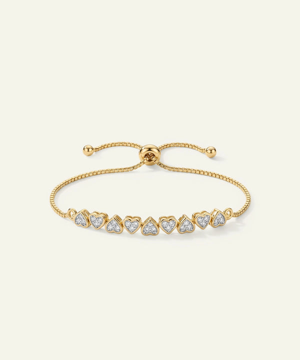 Gold bracelet with heart-shaped diamond accents on a white background